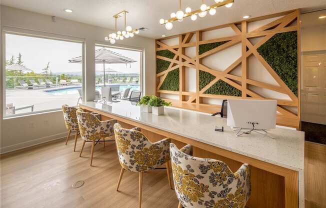 A kitchen with a white counter and yellow chairs.