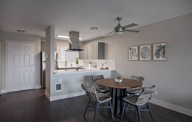 A modern kitchen with a dining table set for four.