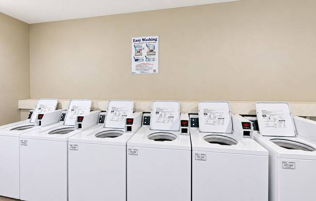 Community laundry room with six top-loading washing machines at Elevation 3505 in Atlanta, GA.