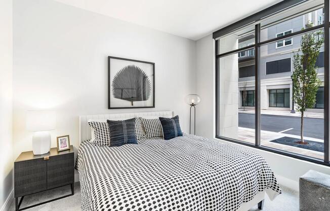 Retreat to bright, airy bedrooms at Modera Liberty Row, where expansive windows and calming design create a peaceful Charlotte escape.
