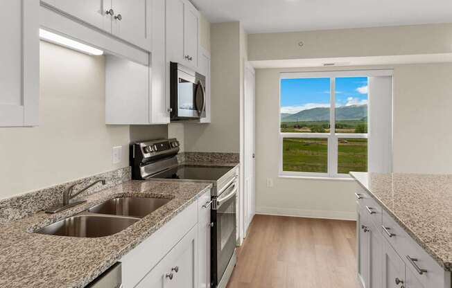 A kitchen with granite countertops and white cabinets.