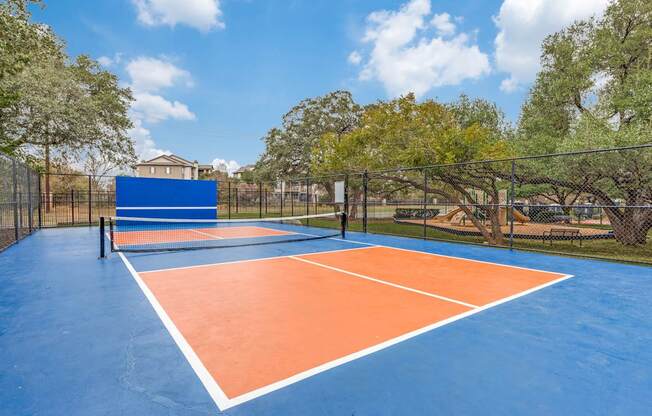 A tennis court with blue and orange colors and a net.