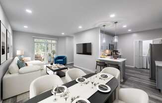 a living room and kitchen with white furniture and a tv