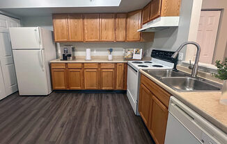 a kitchen with white appliances and wooden cabinets