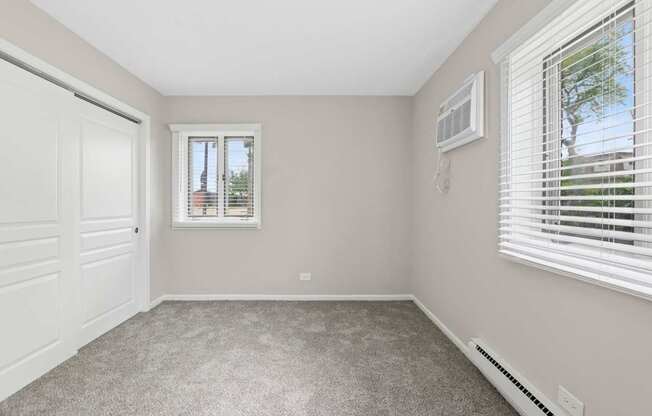 A bedroom with a window and a door.