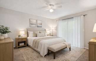 A bedroom with a large bed and a ceiling fan.
