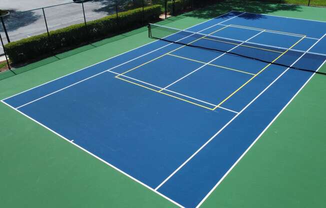 a blue and green tennis court with yellow lines