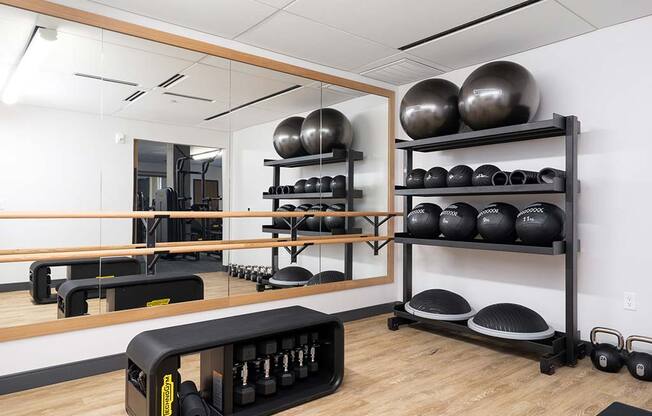 a gym with a mirror and weights on the wall at The Bohen Apartments , Minneapolis, MN, 55408