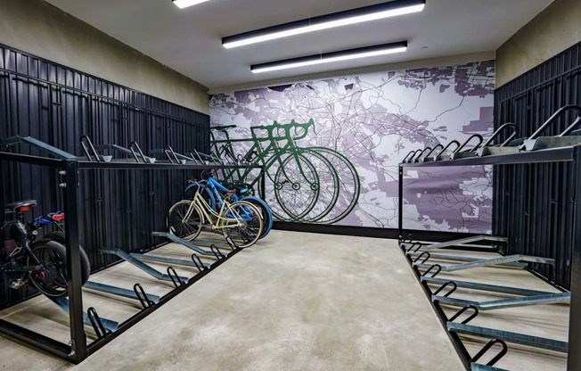 a room filled with bikes and a mural of a city on the wall at NoMa Apartments, Walnut Creek, CA