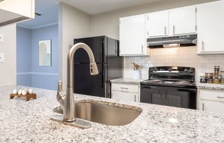 a kitchen with granite counter tops and black appliances