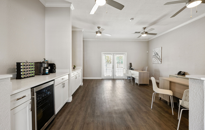 Sleek modern interior with elegant white cabinetry, gleaming wood floors, and ample natural light through double French doors.