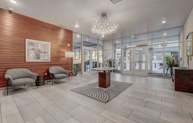 A modern waiting room with a wooden wall and a chandelier.
