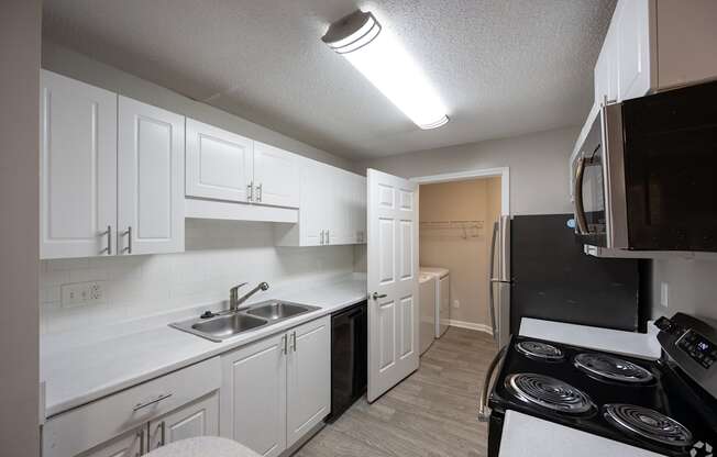 A kitchen with white cabinets and a black stove top.