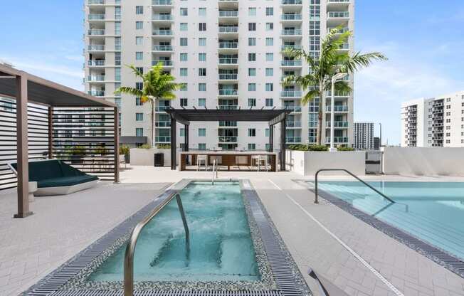 a pool and hot tub on a roof with a building in the background