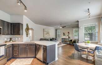 A modern kitchen with dark wood cabinets and a white island.
