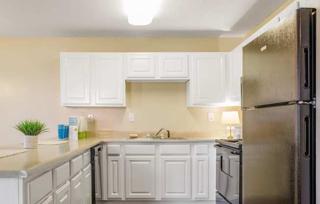 a kitchen with white cabinets and black appliances