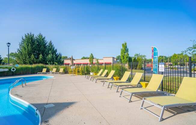 a row of lounge chairs next to a swimming pool at Traditions at Slate Ridge, Reynoldsburg