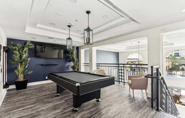 a game room with a pool table and a tv