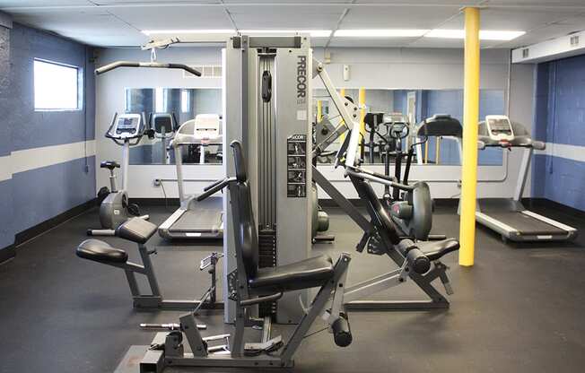 A gym with a variety of equipment including a leg press machine.