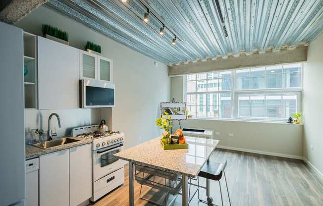 a kitchen with white appliances and a table and a window