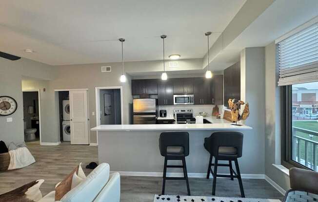 A modern kitchen with a bar area and a dining table.