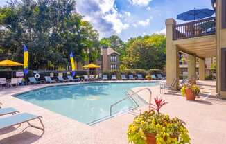 a swimming pool with lounge chairs and umbrellas at homewood suites by hilton
