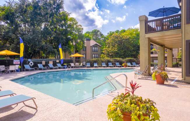 a swimming pool with lounge chairs and umbrellas at homewood suites by hilton