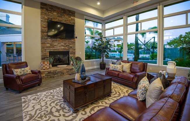 A living room with a fireplace and leather furniture.