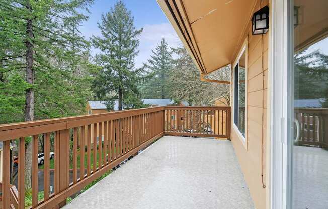A balcony with a railing and a view of trees.