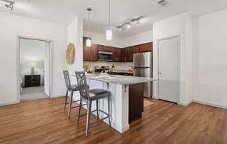 A kitchen with a white island and a single chair.