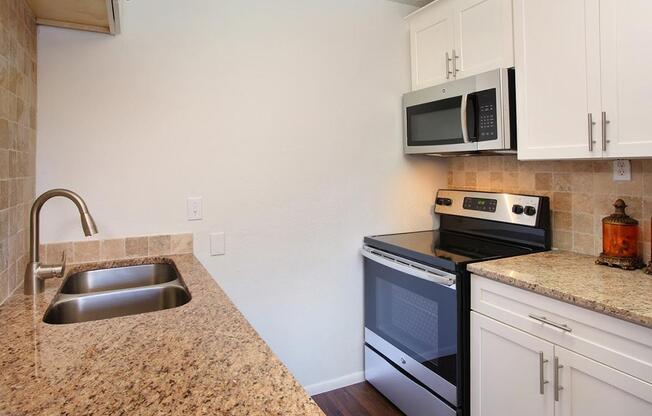 a kitchen with a stove a sink and a microwave