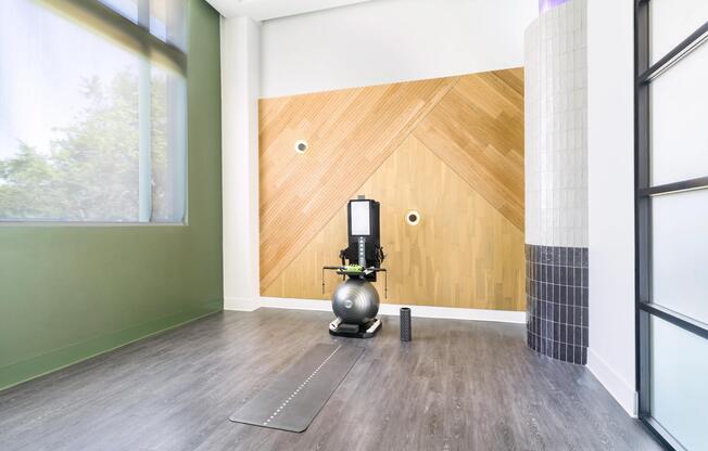 Wellness studio with open floor space, strength equipment, and natural light designed for focused training, stretching, and recovery routines.
