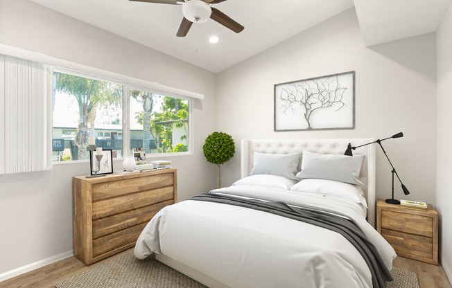 a white bedroom with a large bed and a ceiling fan