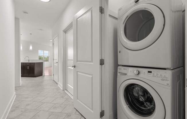 A laundry room with a washer and dryer stacked on top of each other.