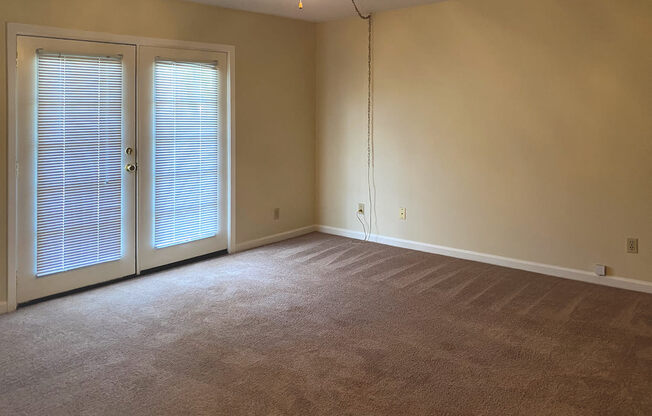 large living room with ceiling fan and french doors to deck