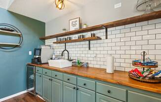 A kitchen with a blue wall and a wooden counter.