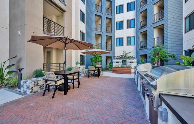 A patio with a table and chairs and an umbrella.