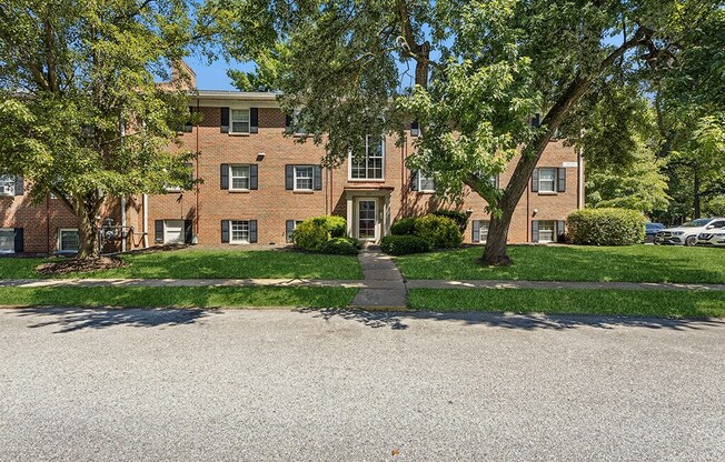 a large brick apartment building with trees in front of it