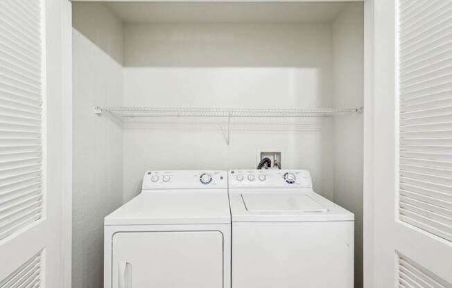 A white washing machine and dryer in a small laundry room.