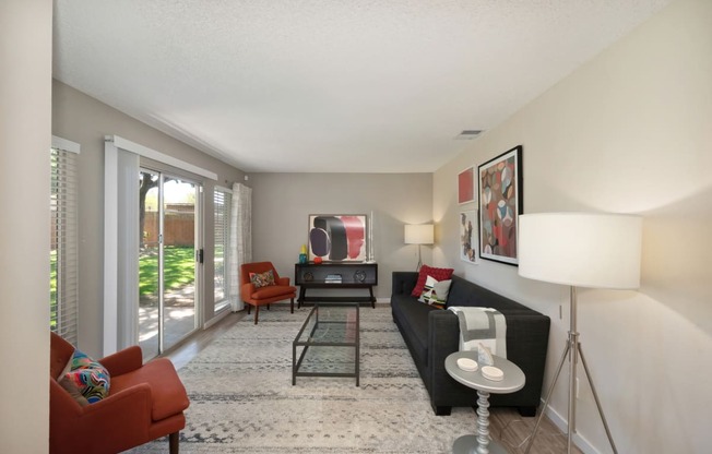 a living room with a couch and chairs and a tv