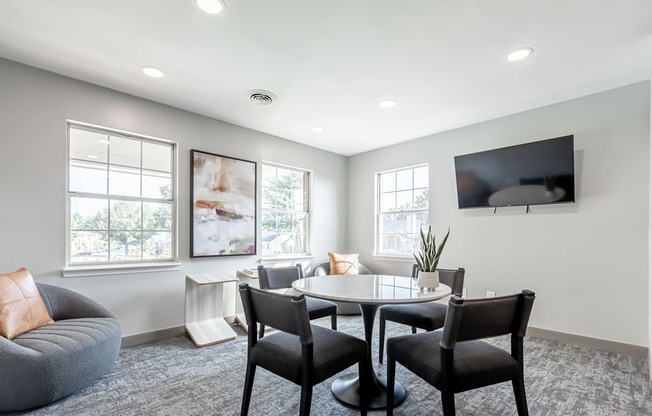 Littlestone Apartments community lounge with a table in front of a mounted tv