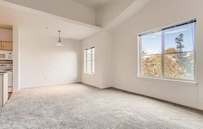 Fairview Apartments for Rent - Spacious Living Room with Carpet, Two Large Windows and Dining Area.