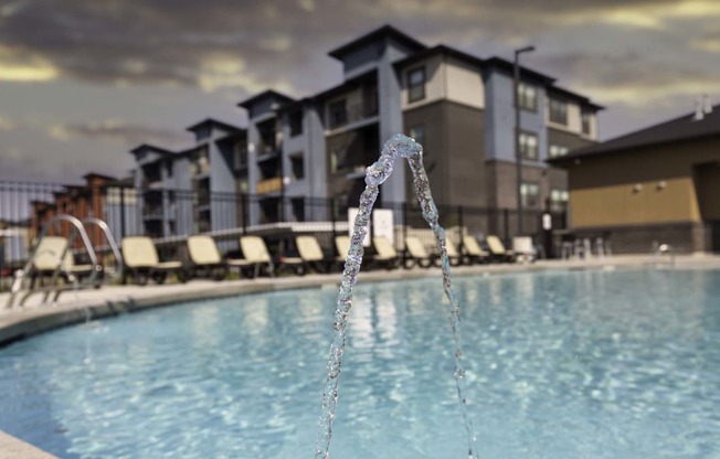 a pool with a faucet in front of a building