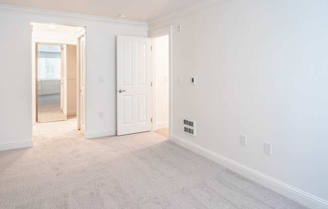 a bedroom with white walls and carpet