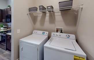 a laundry room with two washers and a dryer
