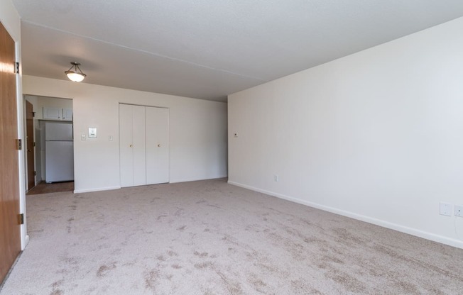 a bedroom with white walls and carpet