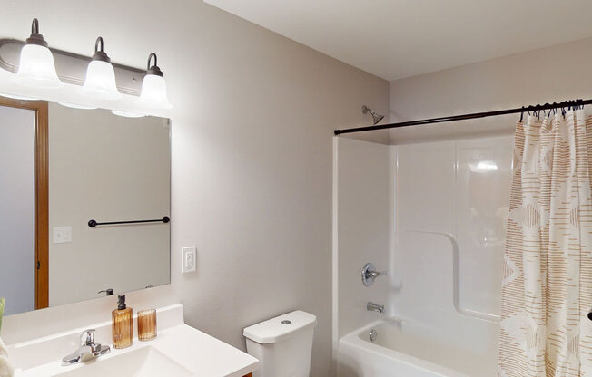 a bathroom with a shower and a sink and a mirror