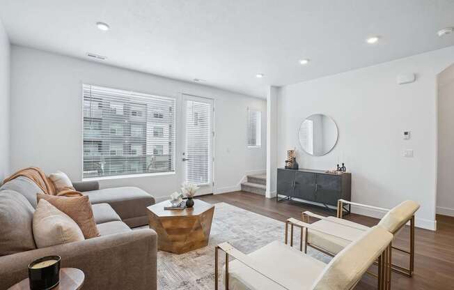 A living room with a brown couch, a white chair, and a wooden coffee table.