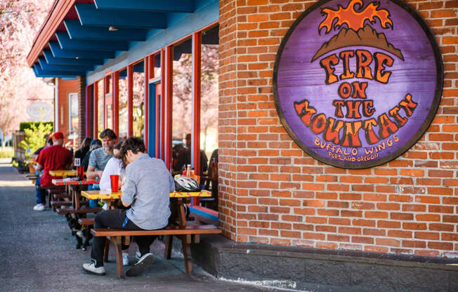 people sitting at tables outside a fire on the mountain restaurant