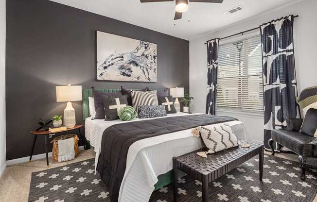A bedroom with a large bed, a chair, and a painting on the wall.